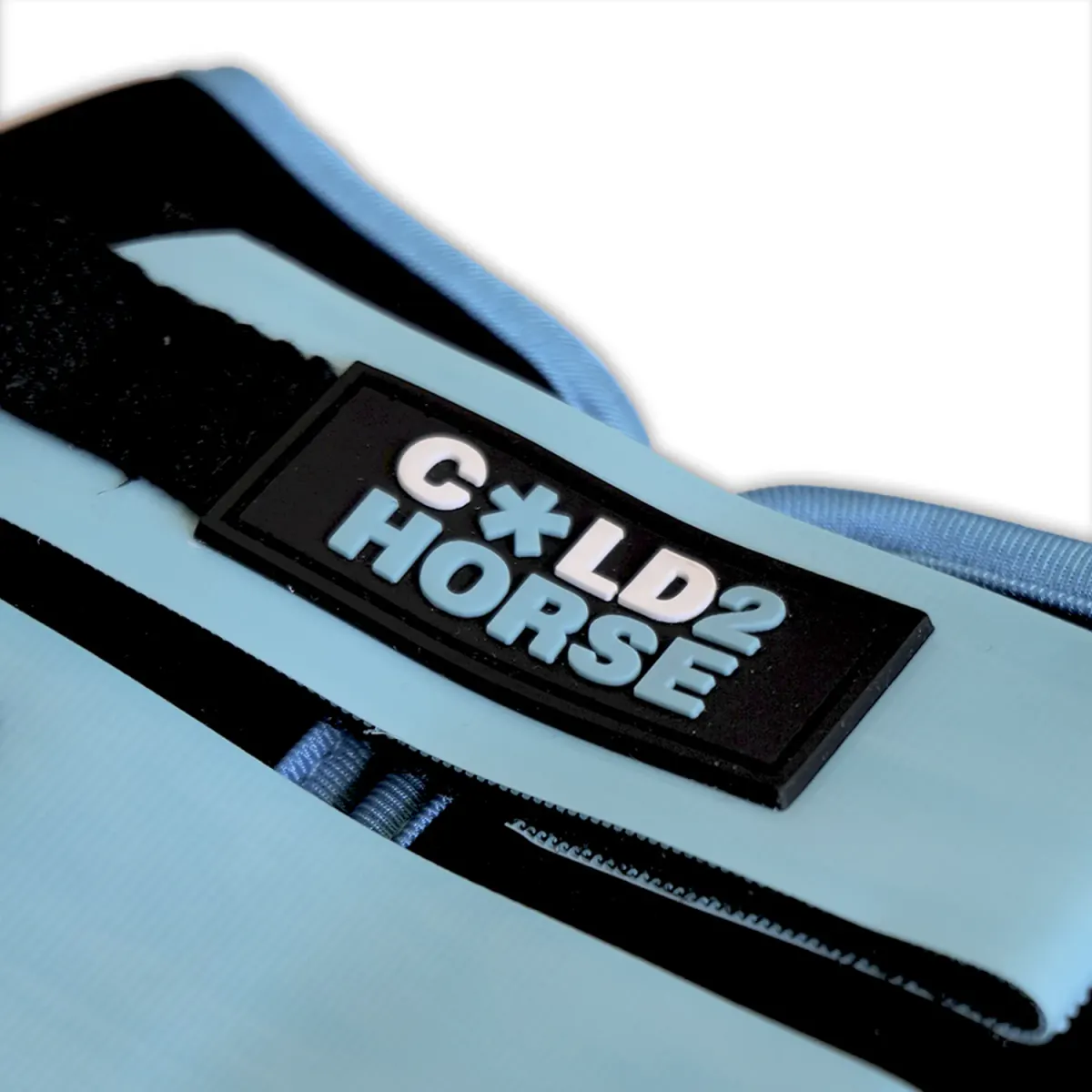 Detalle del emblema Cold2Horse en relieve sobre la cincha de velcro